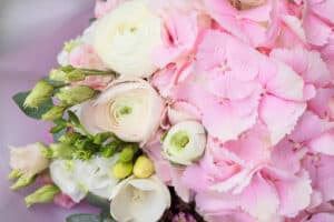 Stylish floral bouquet with pink hydrangea and Ranunculus asiaticus in contrasting pink wrapping paper. Designer flower bouquet from a florist